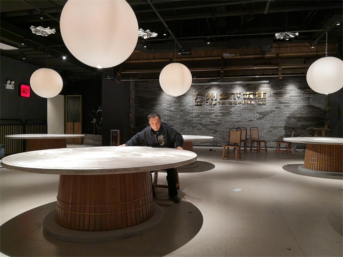 海德利（lì）總經理在廣州鄉（xiāng）下飯莊檢查大理石（shí）圓餐桌打磨是（shì）否夠光滑