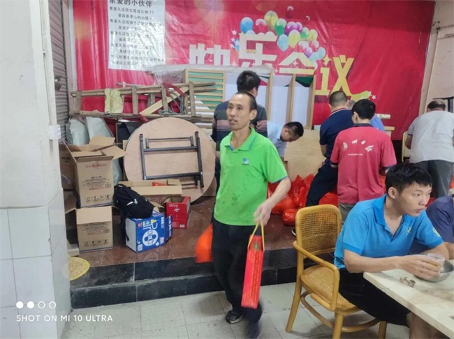 聚餐後同事們提著公司發放的月餅和柚子回家（jiā）